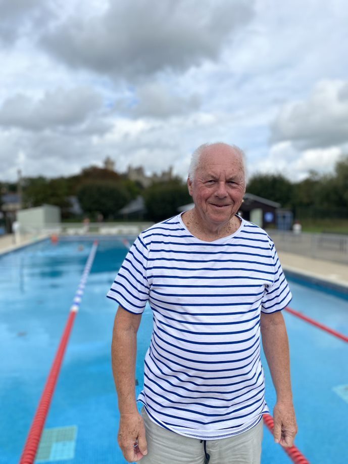 An elderly man in a t-shirt posing next to one of Arundel Lido's outdoor swimming pools.